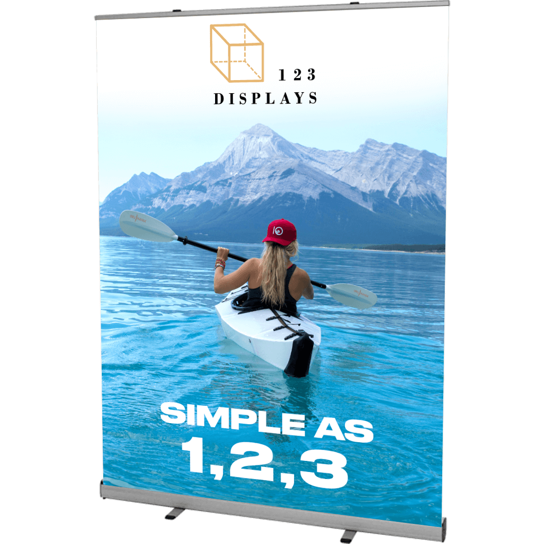 A kayaker paddles on a pristine mountain lake with snow-capped peaks in the background. Promotional text for 123 Displays reads 'SIMPLE AS 1,2,3'.